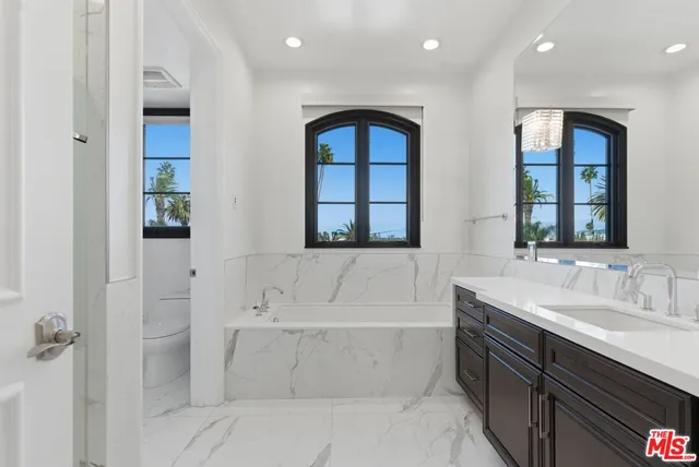 a bathroom with a bathtub sink and mirror