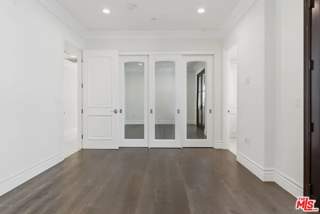 an empty room with wooden floor and window