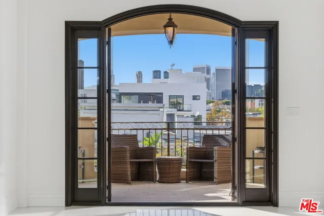 a view of living room with stainless steel appliances wooden floor and cabinet