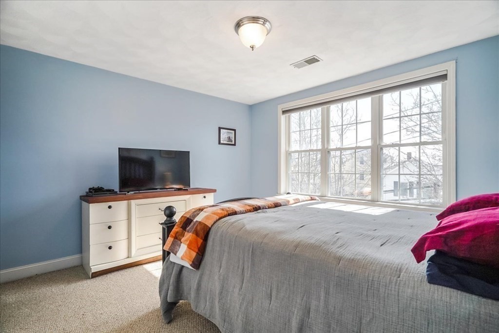 103 Elliott Street, Unit 12 Beverly, MA 01915 - Photo 17 of 25 a bedroom with a bed and a flat screen tv