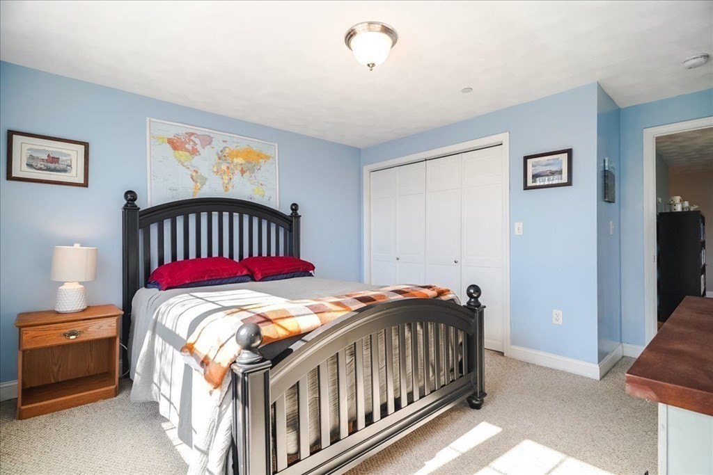 103 Elliott Street, Unit 12 Beverly, MA 01915 - Photo 18 of 25 a bedroom with a bed and a baby crib