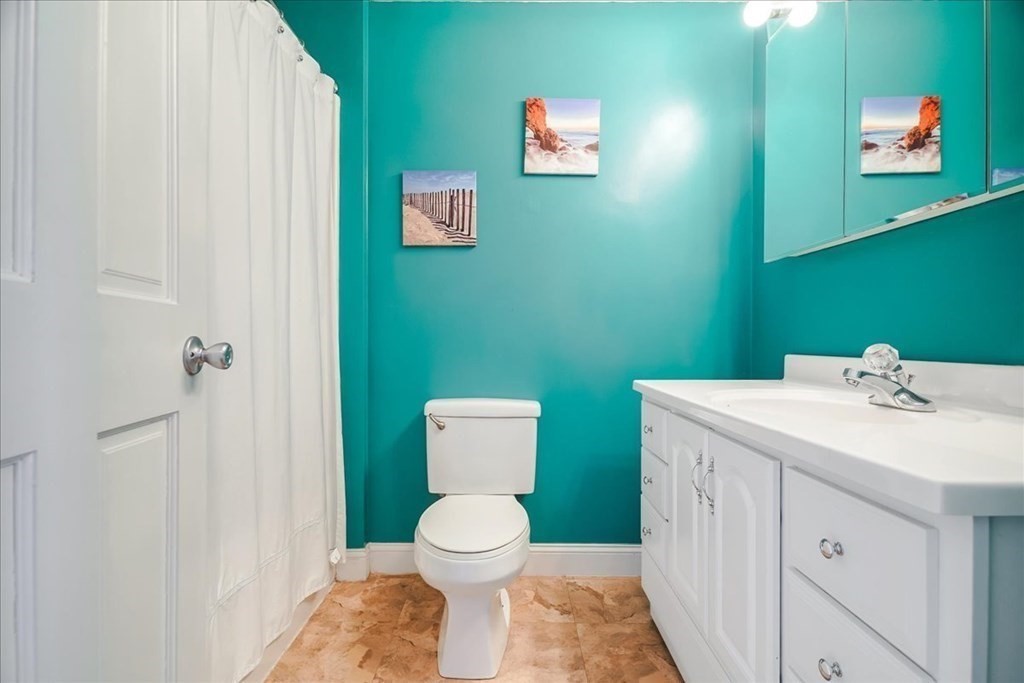 103 Elliott Street, Unit 12 Beverly, MA 01915 - Photo 19 of 25 a bathroom with a toilet sink and a mirror