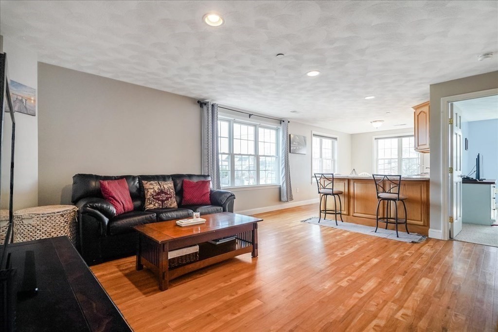 103 Elliott Street, Unit 12 Beverly, MA 01915 - Photo 4 of 25 a living room with furniture and a wooden floor