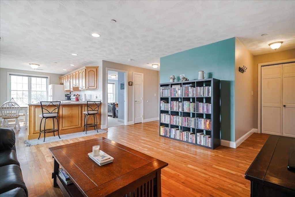 103 Elliott Street, Unit 12 Beverly, MA 01915 - Photo 5 of 25 a living room with furniture and a book shelf
