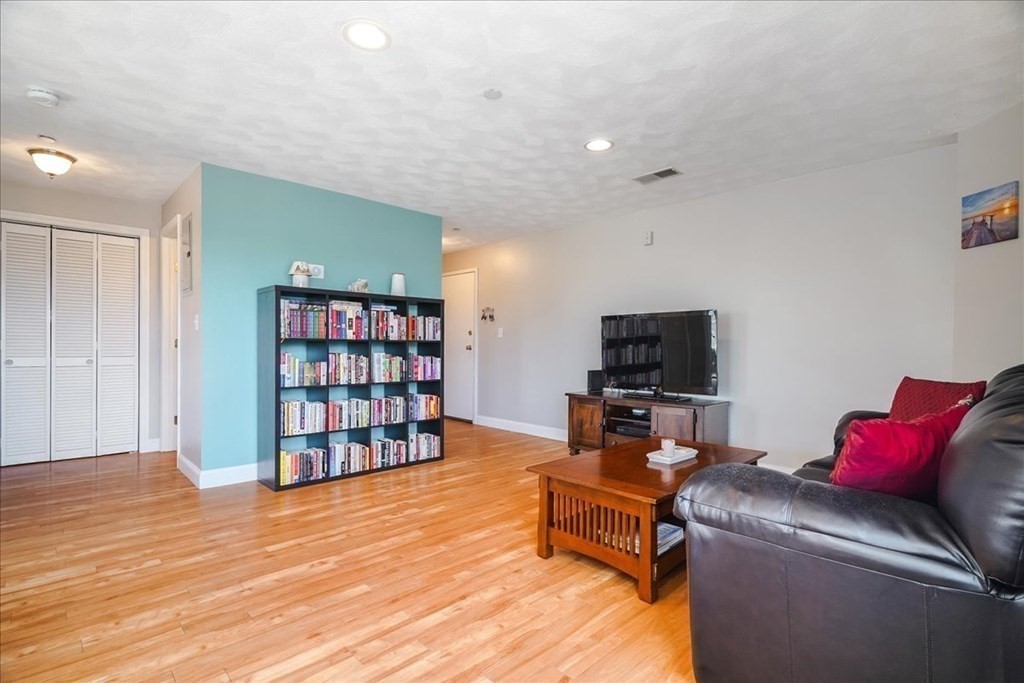 103 Elliott Street, Unit 12 Beverly, MA 01915 - Photo 6 of 25 a living room with furniture or flat screen tv and a book shelf
