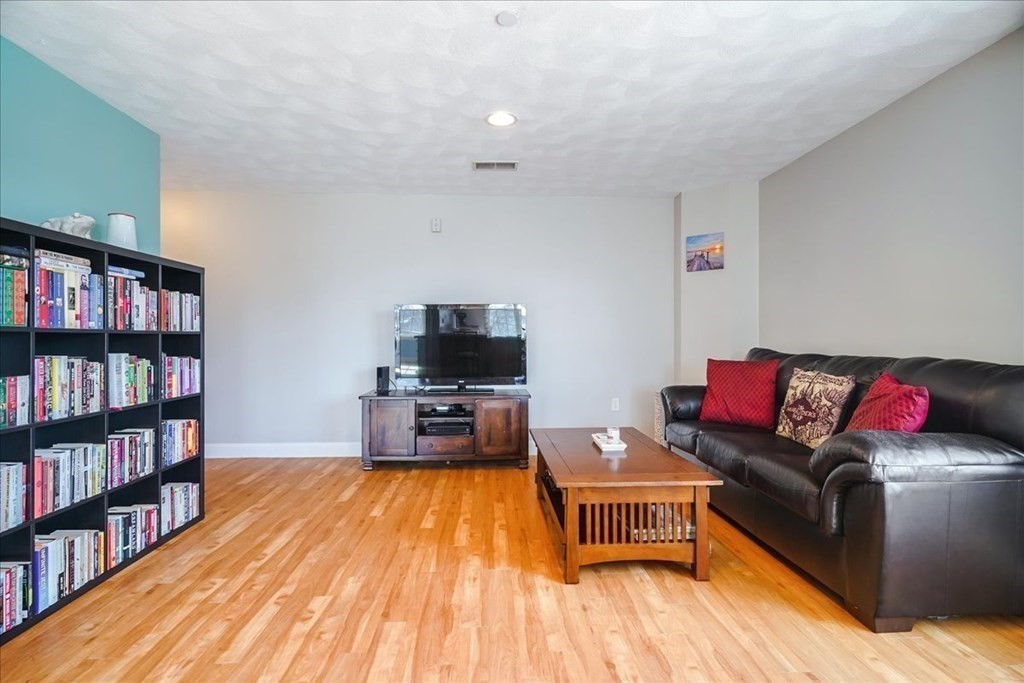 103 Elliott Street, Unit 12 Beverly, MA 01915 - Photo 7 of 25 a living room with furniture and a flat screen tv