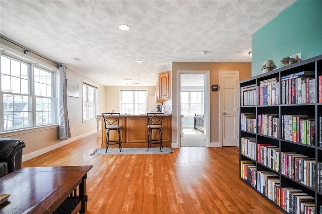 103 Elliott Street, Unit 12 Beverly, MA 01915 - Photo 8 of 25 a living room with lots of furniture and a book shelf