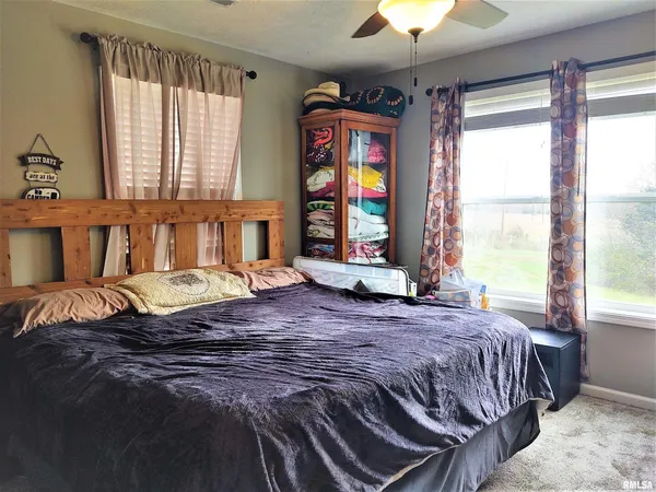 a bedroom with a bed and a chandelier next to a window