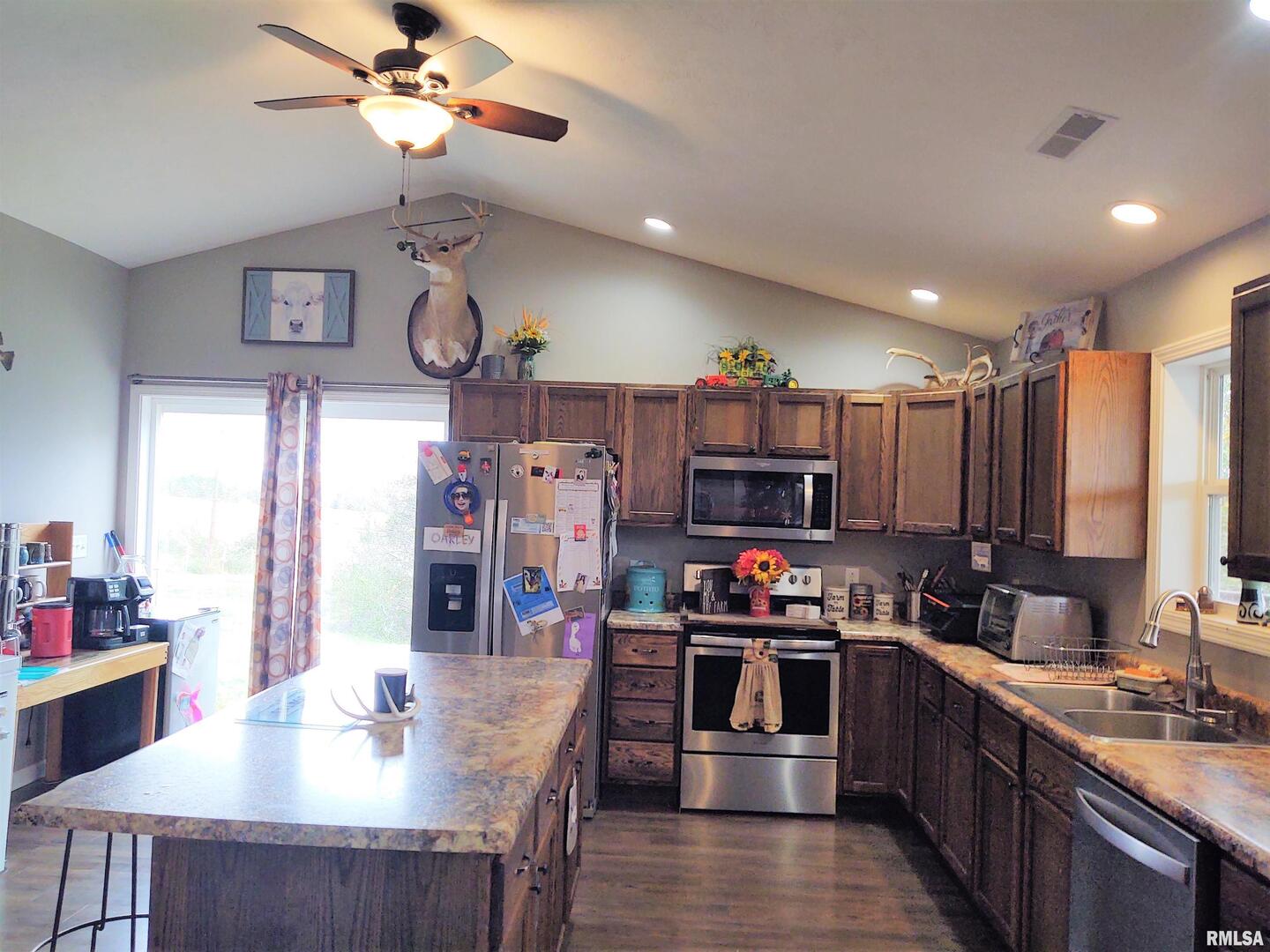 1470 Old Bloomfield Road Vienna, IL 62995 - Photo 9 of 25 a kitchen with stainless steel appliances a table chairs and a refrigerator