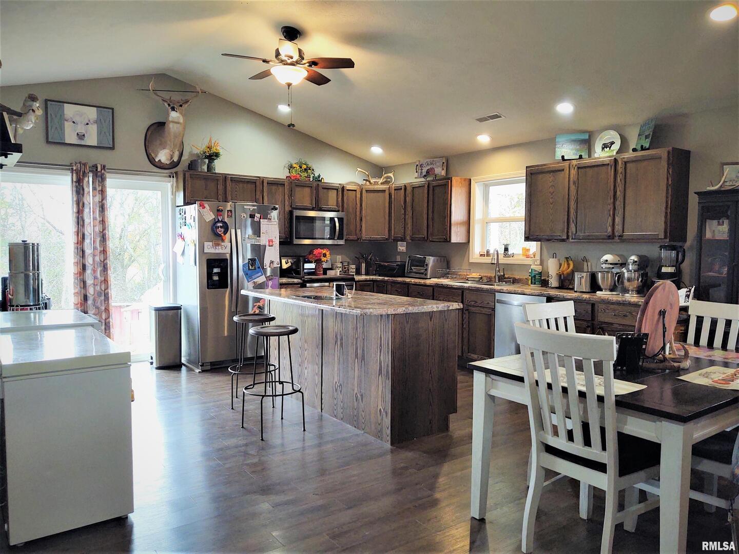 1470 Old Bloomfield Road Vienna, IL 62995 - Photo 10 of 25 a kitchen with stainless steel appliances kitchen island granite countertop a table chairs and a refrigerator