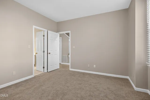 a view of empty room with wooden floor and fireplace