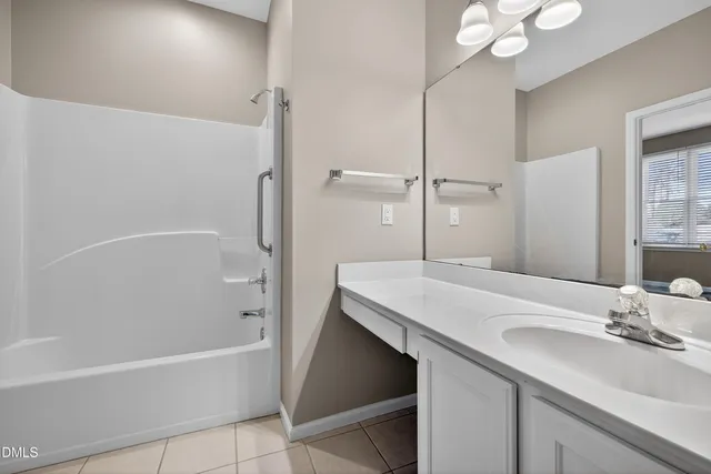 a view of an empty room with wooden floor fireplace and a window