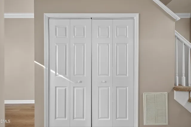 a view of an empty room with wooden floor & closet