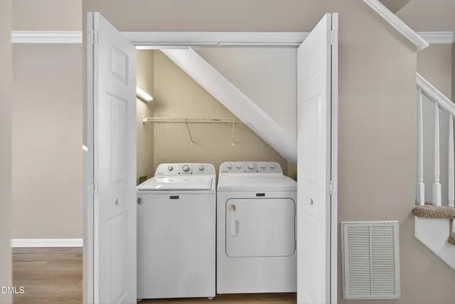 a view of an empty room with wooden floor and windows