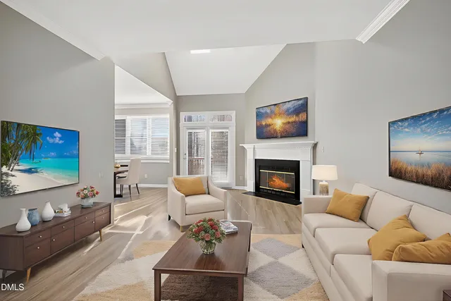 a view of an empty room with wooden floor fireplace and a window