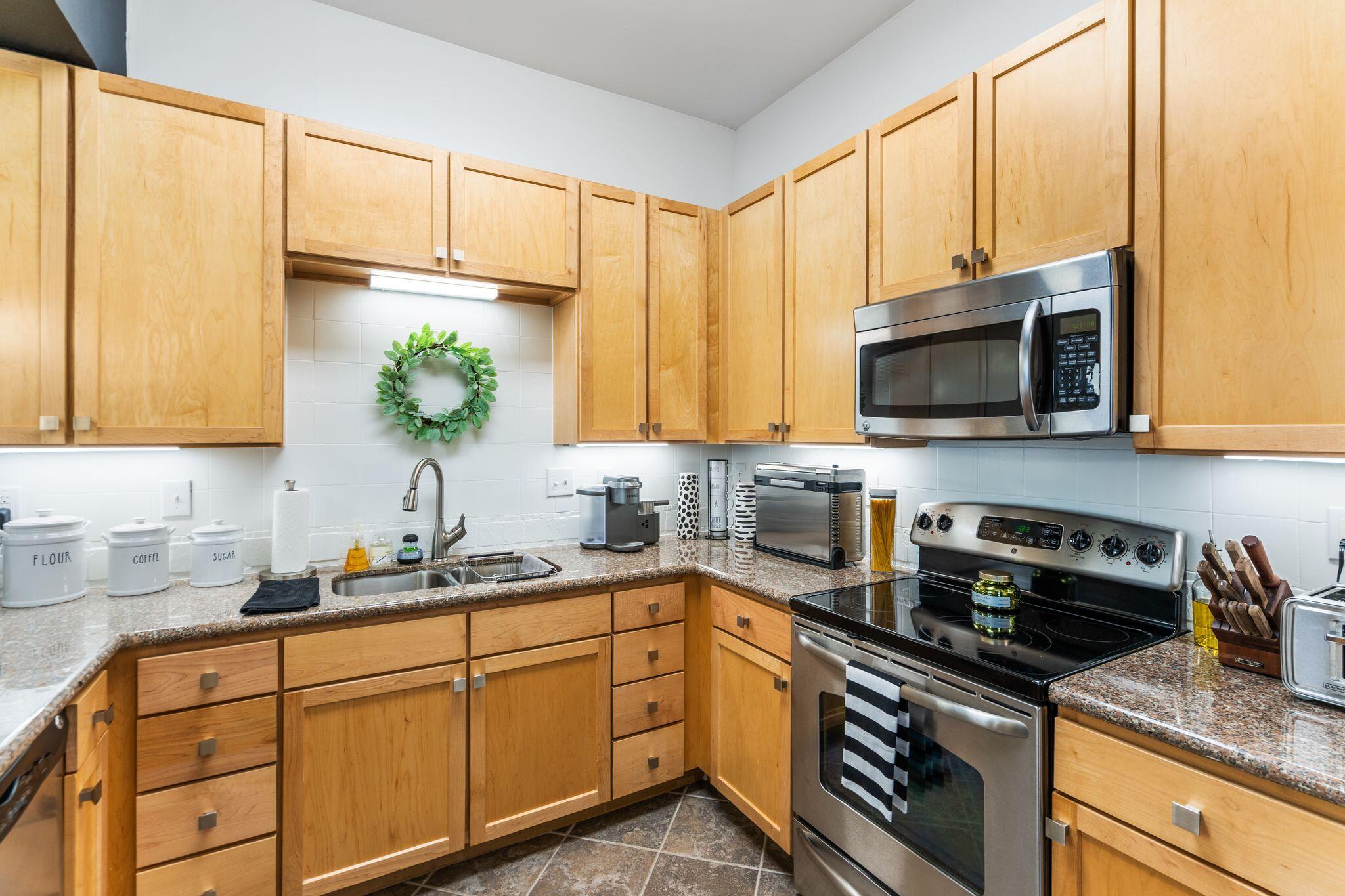 8700 Front Beach Road, Unit 6310 Panama City Beach, FL 32407 - Photo 4 of 42 a kitchen with stainless steel appliances a sink a stove and microwave