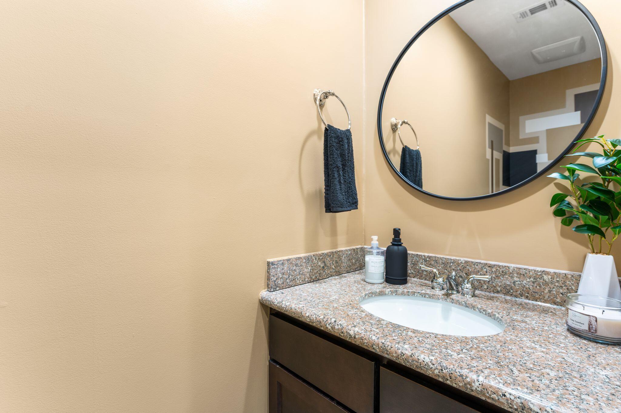8700 Front Beach Road, Unit 6310 Panama City Beach, FL 32407 - Photo 6 of 42 a bathroom with a granite countertop sink and a mirror