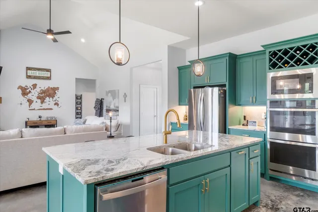 a kitchen with center island a sink stainless steel appliances and cabinets