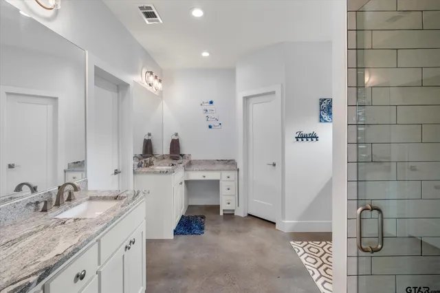 a bathroom with a granite countertop sink and a mirror