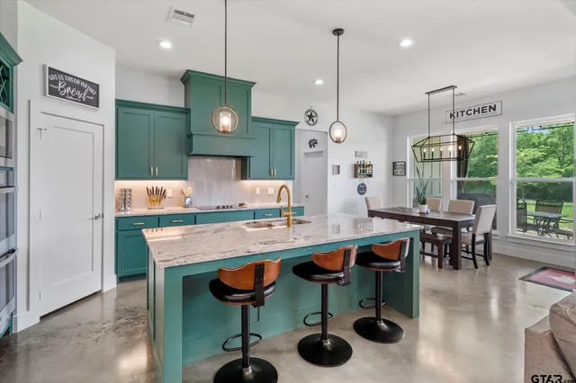 a kitchen with cabinets and chairs in it
