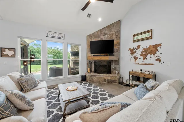 a living room with furniture a flat screen tv and a fireplace