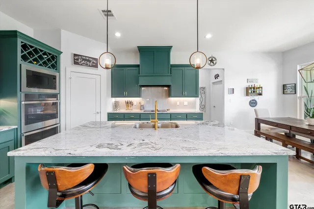a kitchen with stainless steel appliances granite countertop a stove a sink and a wooden floors