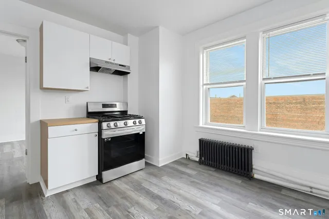 a kitchen with stainless steel appliances a stove a sink and a window