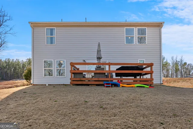 a backyard of a house with barbeque oven table and chairs