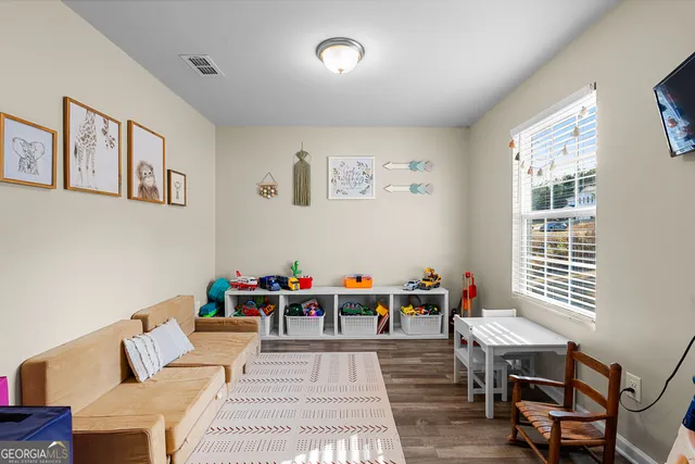 a view of a hallway with wooden floor and a bathroom