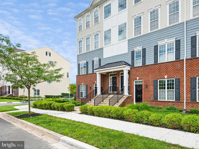 a front view of a house with a yard and potted plants