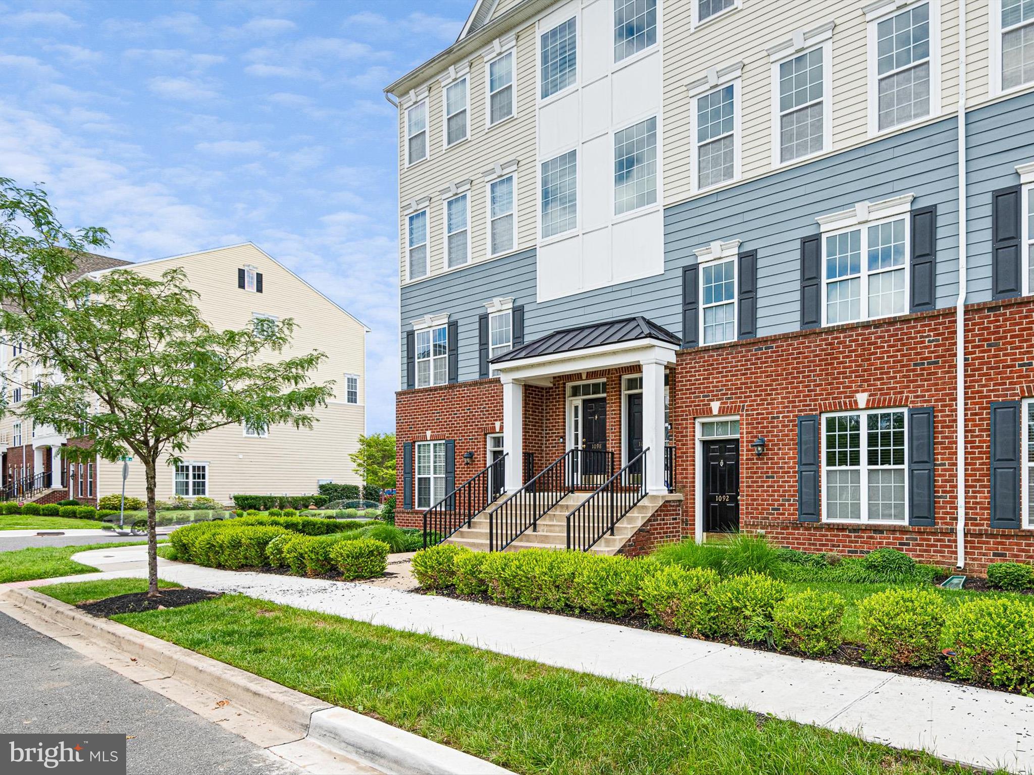 1092 Worth Lane, Unit BL12 Claymont, DE 19703 - Photo 19 of 20 a front view of a house with a yard and potted plants
