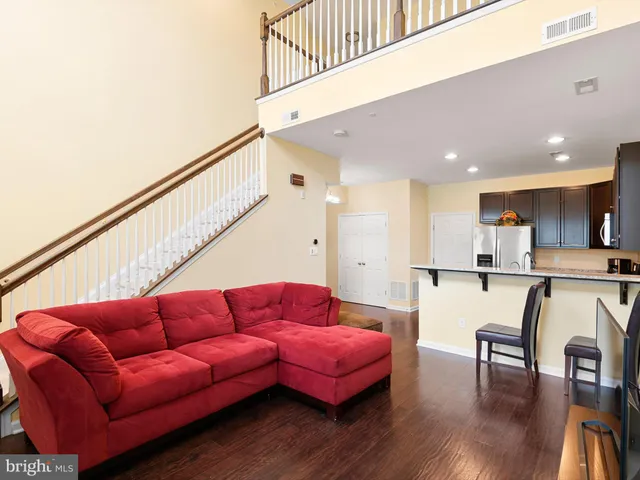 a living room with furniture a wooden floor and a sink
