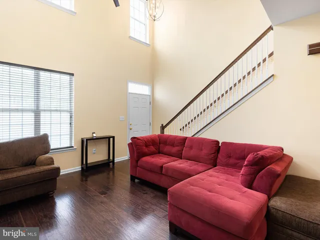 a living room with furniture a couch and a window with wooden floor