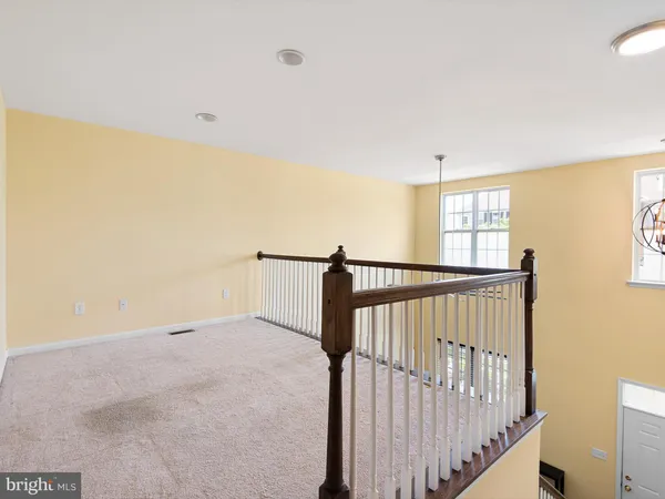 a view of a hallway with wooden floor and windows