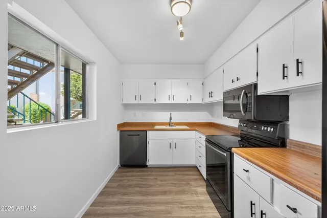 a kitchen with granite countertop a sink stainless steel appliances and cabinets