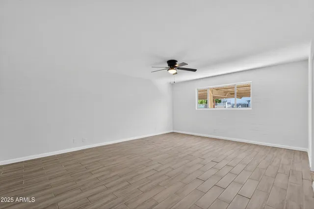 a view of an empty room with wooden floor