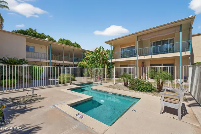 a view of a chair and table in the back yard of the house