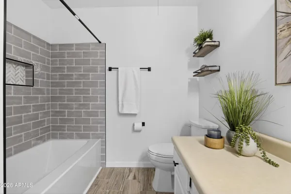 an empty room with wooden floor ceiling fan and windows