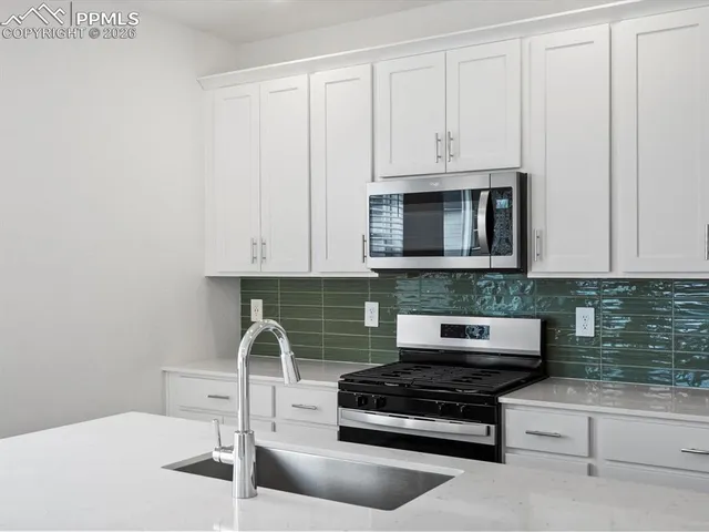 a kitchen with refrigerator and microwave
