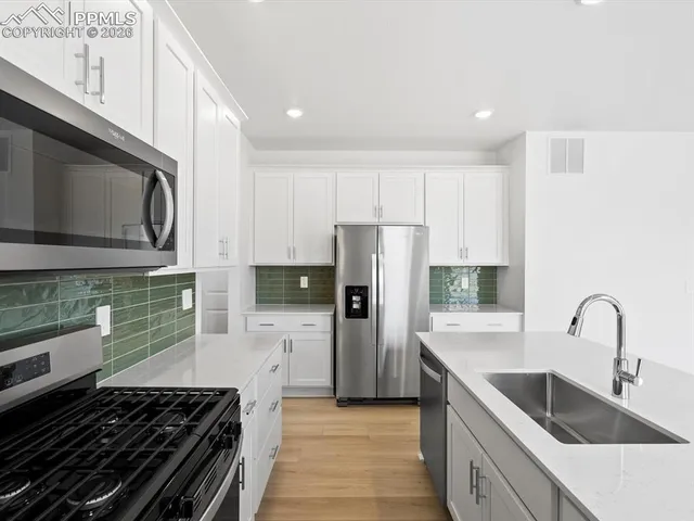 a kitchen with granite countertop a sink and dishwasher with wooden floor