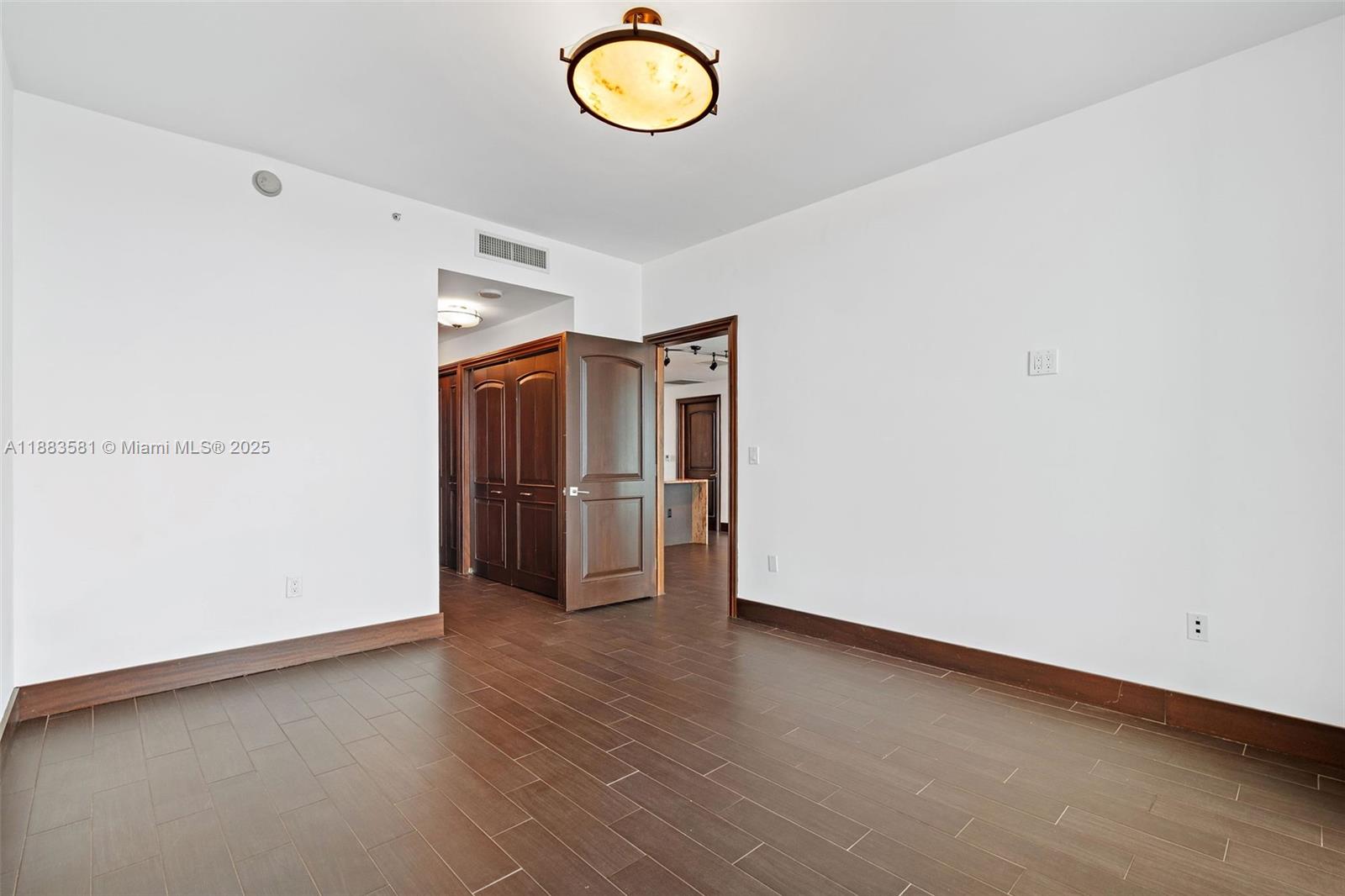 900 Biscayne Boulevard, Unit 3502 Miami, FL 33132 - Photo 19 of 42 a view of an empty room with a window and wooden floor