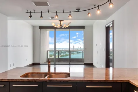 a kitchen with stainless steel appliances granite countertop a sink and a refrigerator