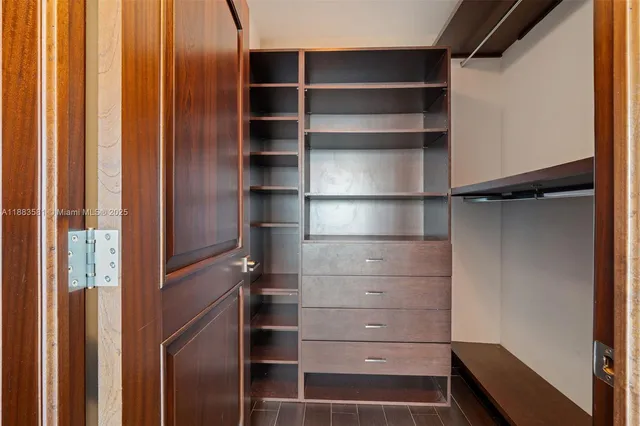 a view of walk in closet with empty racks