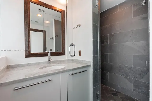 a bathroom with a granite countertop sink and a mirror