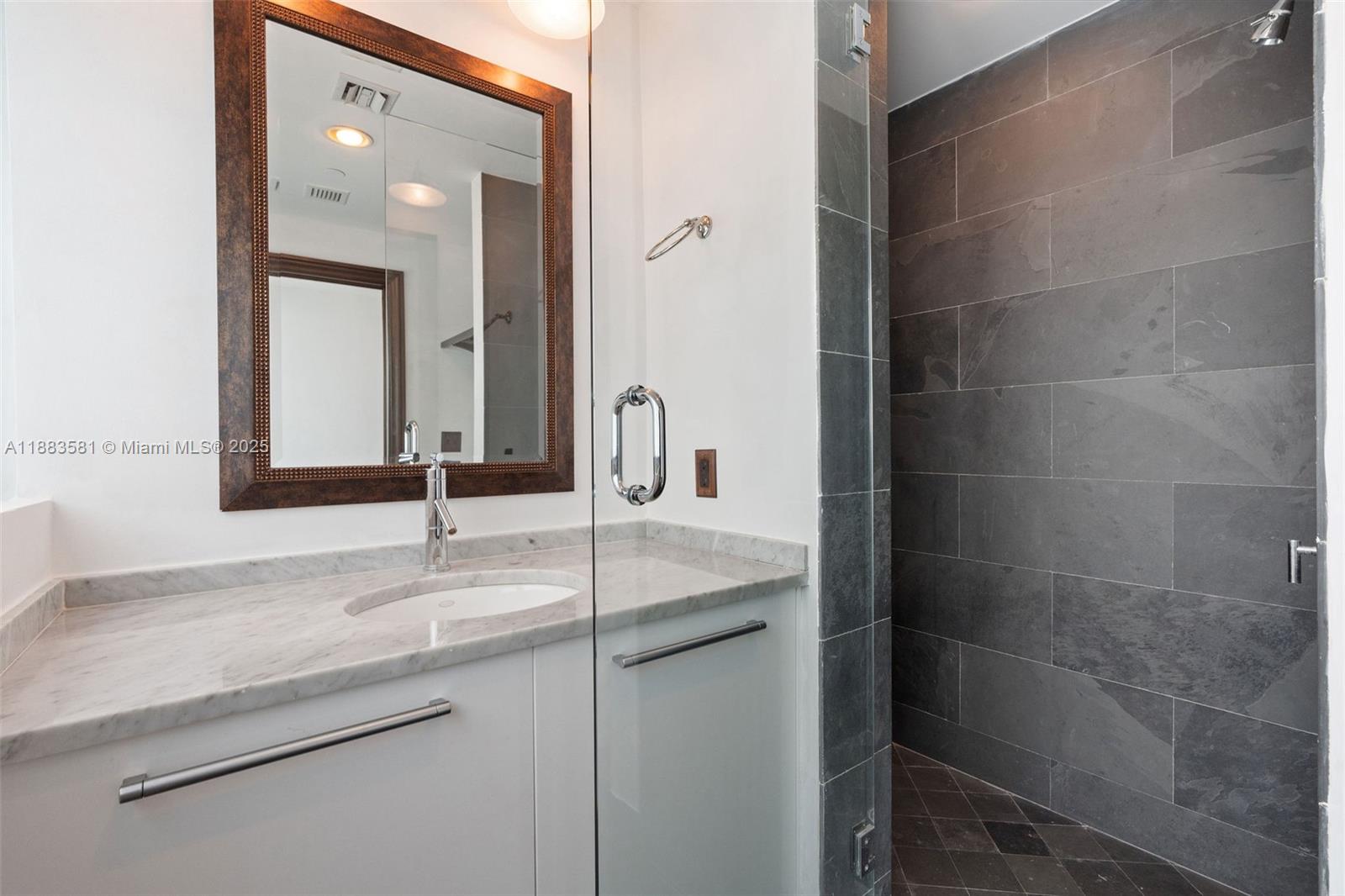 900 Biscayne Boulevard, Unit 3502 Miami, FL 33132 - Photo 32 of 42 a bathroom with a granite countertop sink and a mirror
