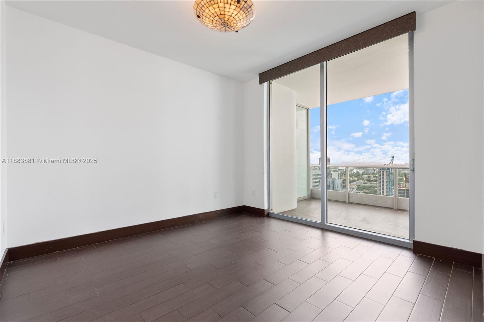900 Biscayne Boulevard, Unit 3502 Miami, FL 33132 - Photo 33 of 42 an empty room with wooden floor and windows