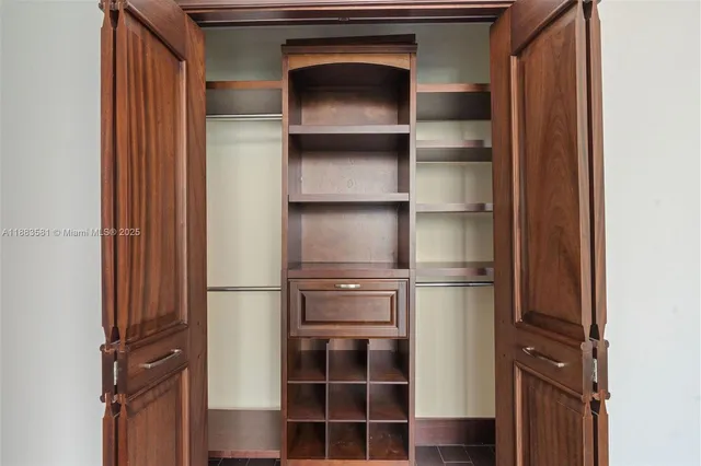 a view of walk in closet with empty racks