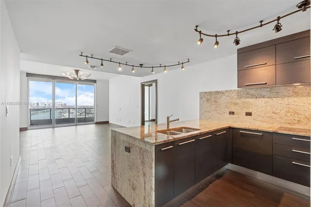 a kitchen with granite countertop a sink and cabinets