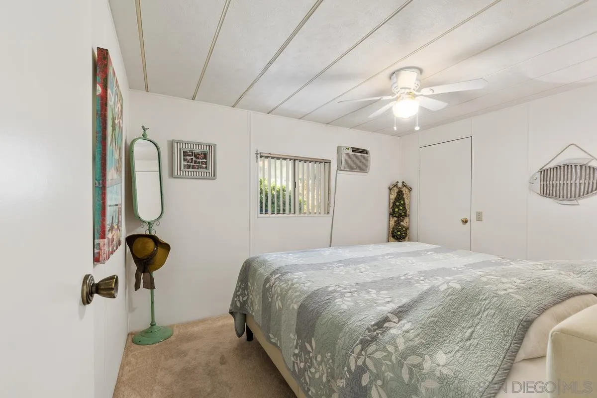 4747 Oak Crest Road, Unit 39 Fallbrook, CA 92028 - Photo 21 of 38 a bedroom with a bed and a chandelier