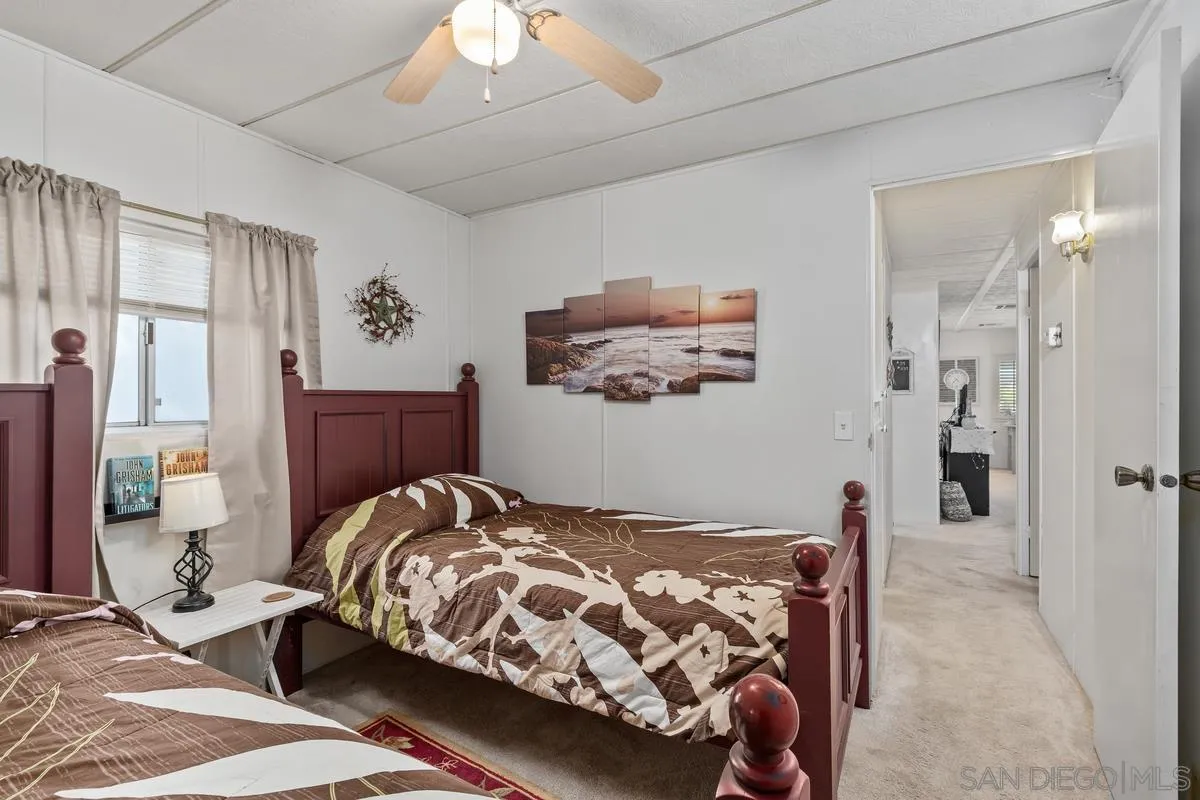 4747 Oak Crest Road, Unit 39 Fallbrook, CA 92028 - Photo 24 of 38 a bedroom with a bed and a chandelier